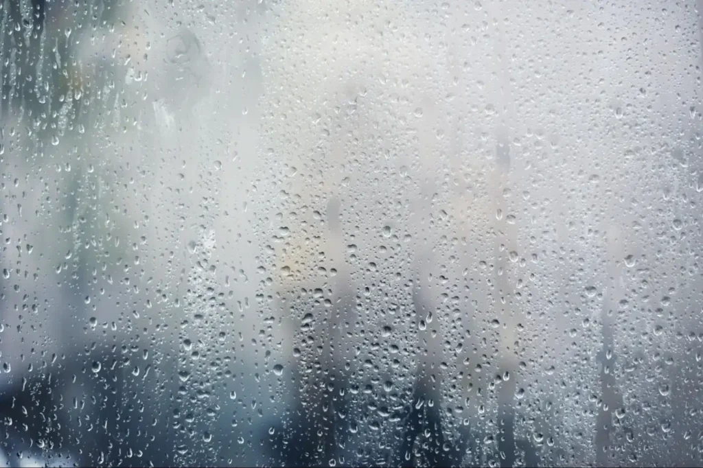 Gouttes de condensation sur la face intérieure d’une vitre embuée