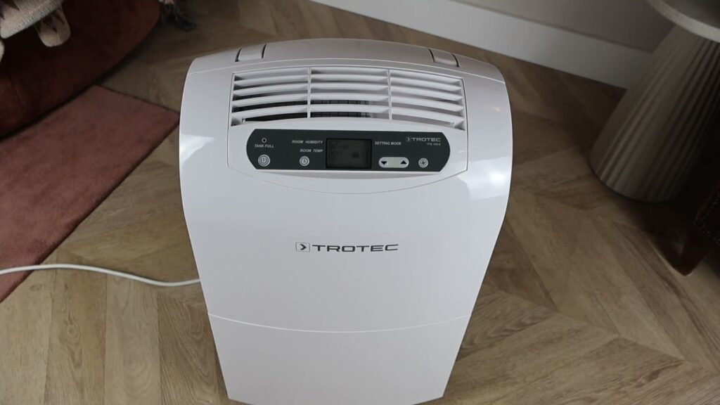 Déshumidificateur Trotec TTK 100 E vu de dessus, posé sur un parquet à bâtons rompus dans le salon